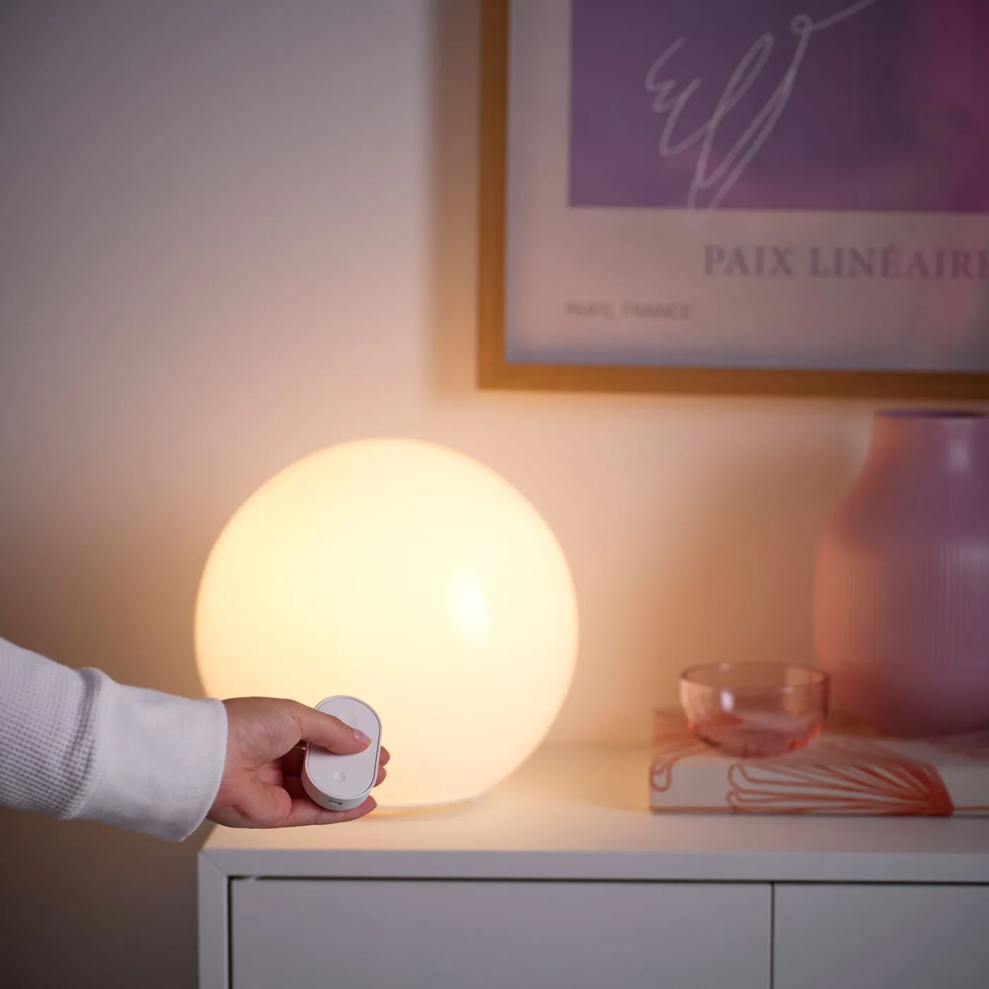 Hand bedient een IKEA Kajplats lamp met de Bilresa knop